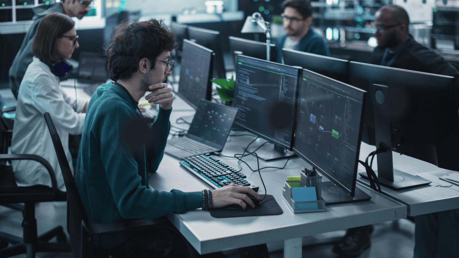 Engineers collaborating on multiple monitors